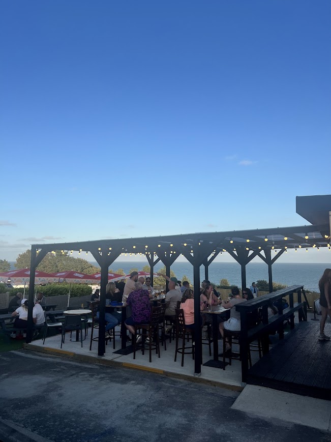 Customers enjoying a drink in the seating area at Sam's Bar with sea views