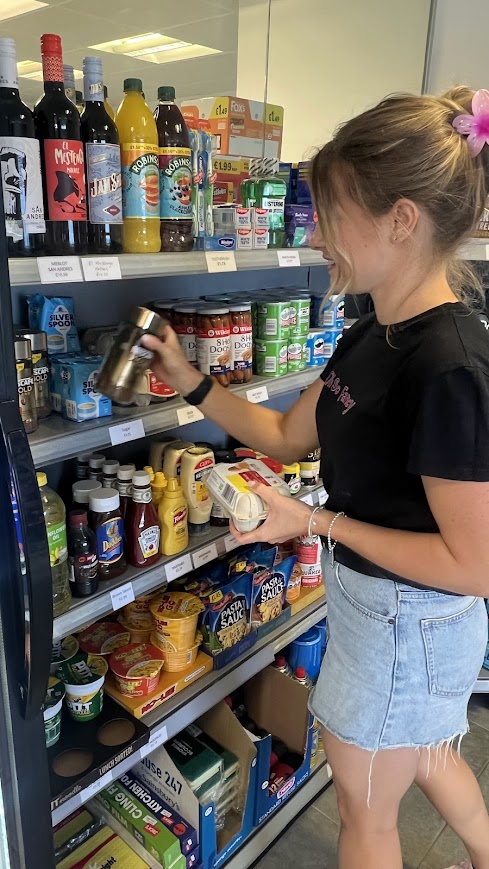 Customer in Kingsdown Camping Shop with product in hand